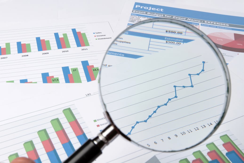 Analyzing Financial Reports Through Magnifying Glass Close-up